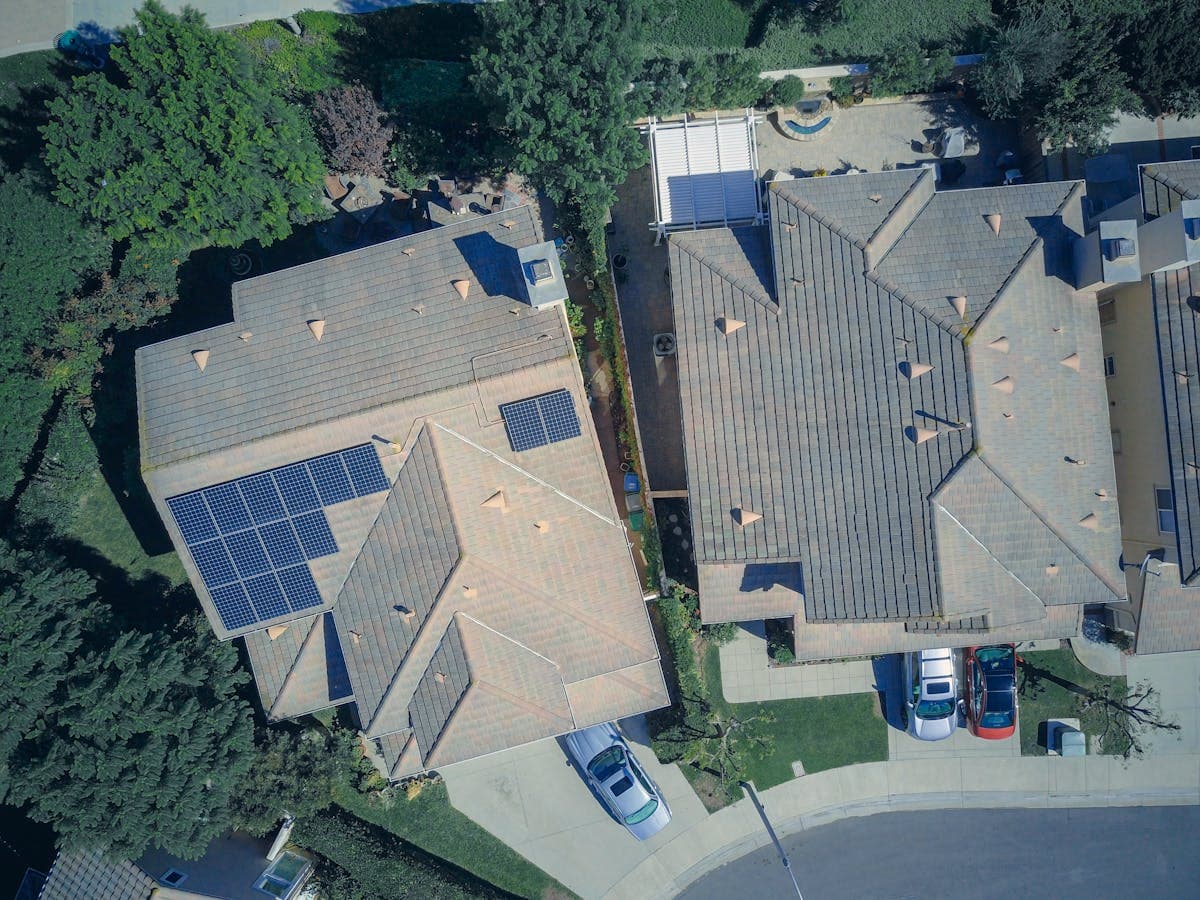 Luchtfoto van woningen met zonnepanelen op pannendaken